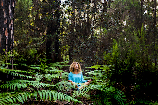 woman meditating in a forest