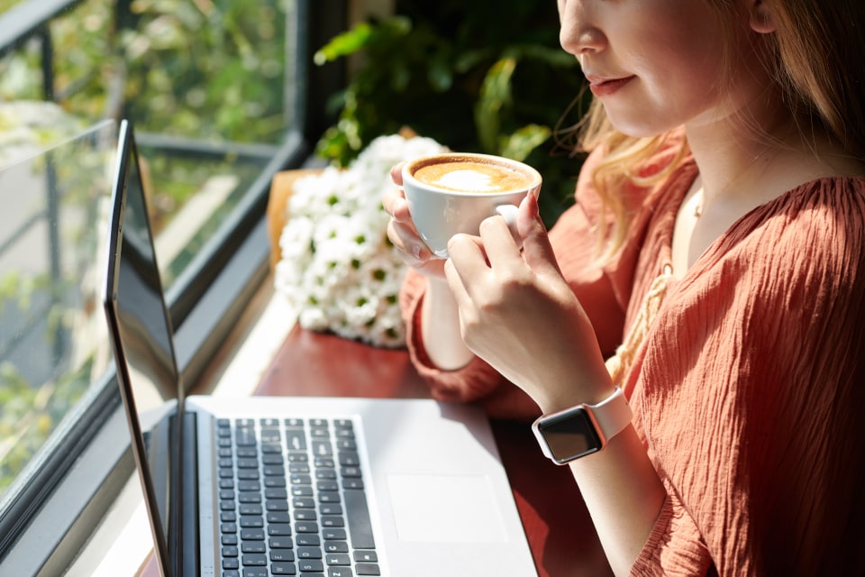 Woman reading an article while drinking coffee