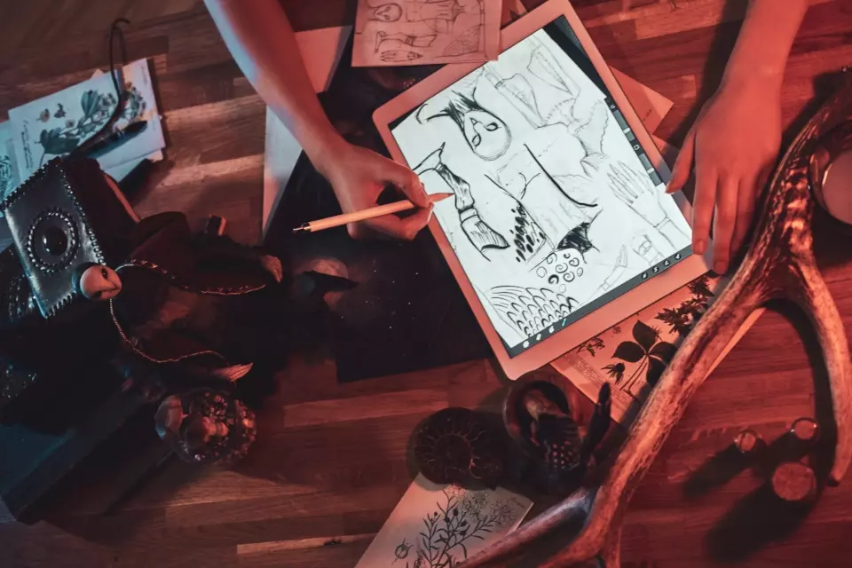 Sketch artist drawing figures on a tablet