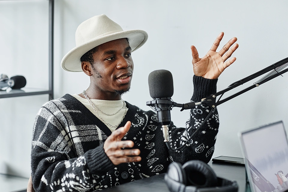 man in a hat talking into a mic representing content creator vs influencer