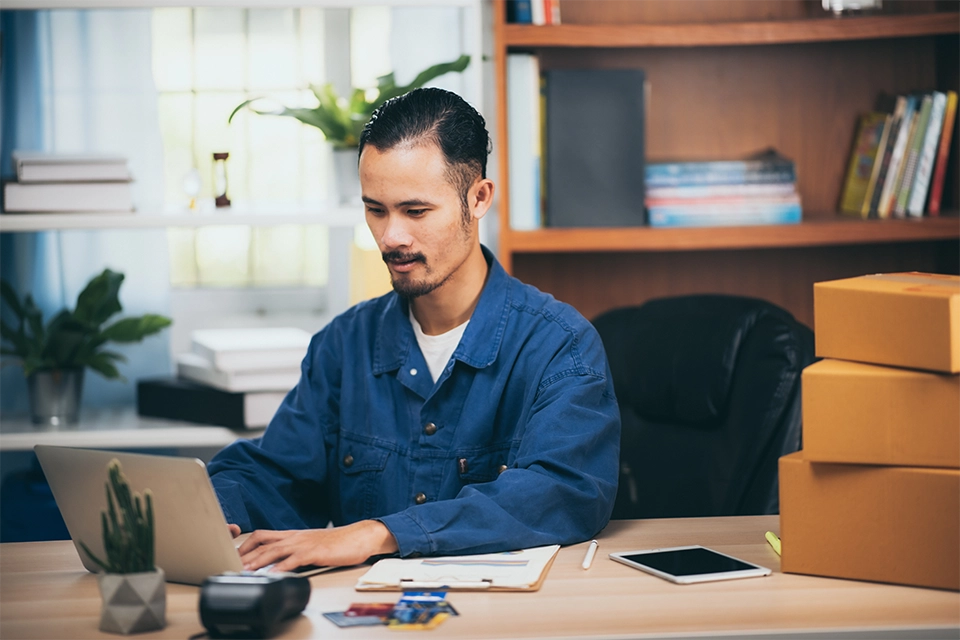 Man working at a desk on his laptop on his ecommerce marketing budget