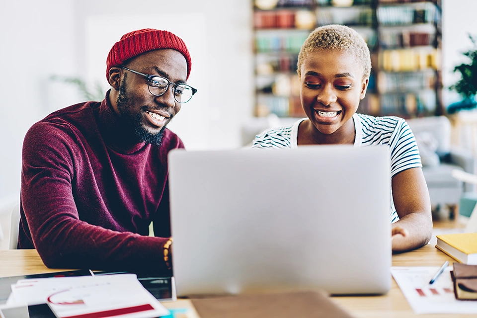 Two people discussing influencer marketing tools on a laptop in an office