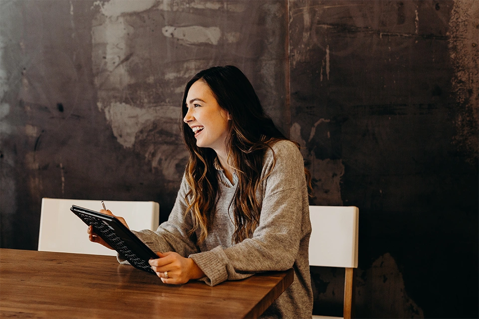 Woman at a table working at one of many available influencer marketing jobs