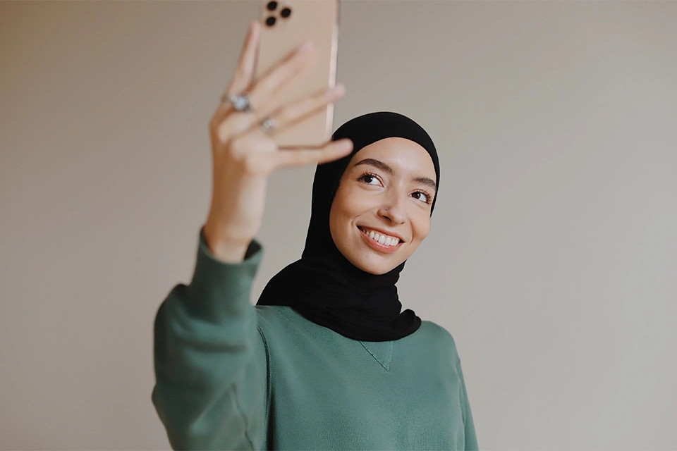 Young Gen Z woman taking a selfie showing another of many TikTok trends for businesses